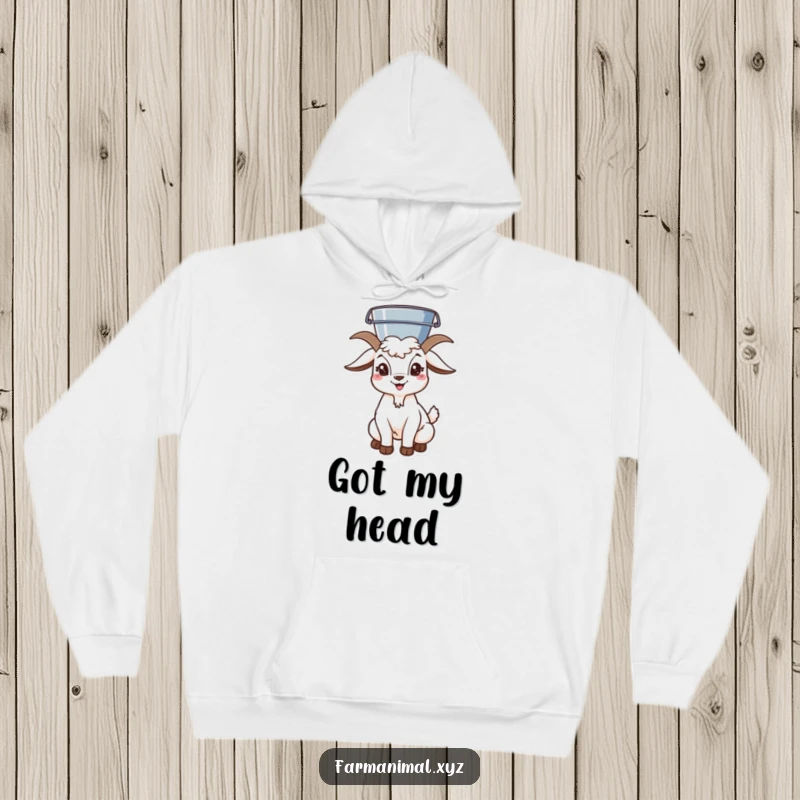 Funny goat character balancing a bucket on its head, depicted on a warm and comfortable hoodie for ultimate fun.